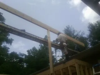 Carpenter setting a ridge beam over a new addition frame — Ice Dam Removal by Roofing Brothers in Dassel
