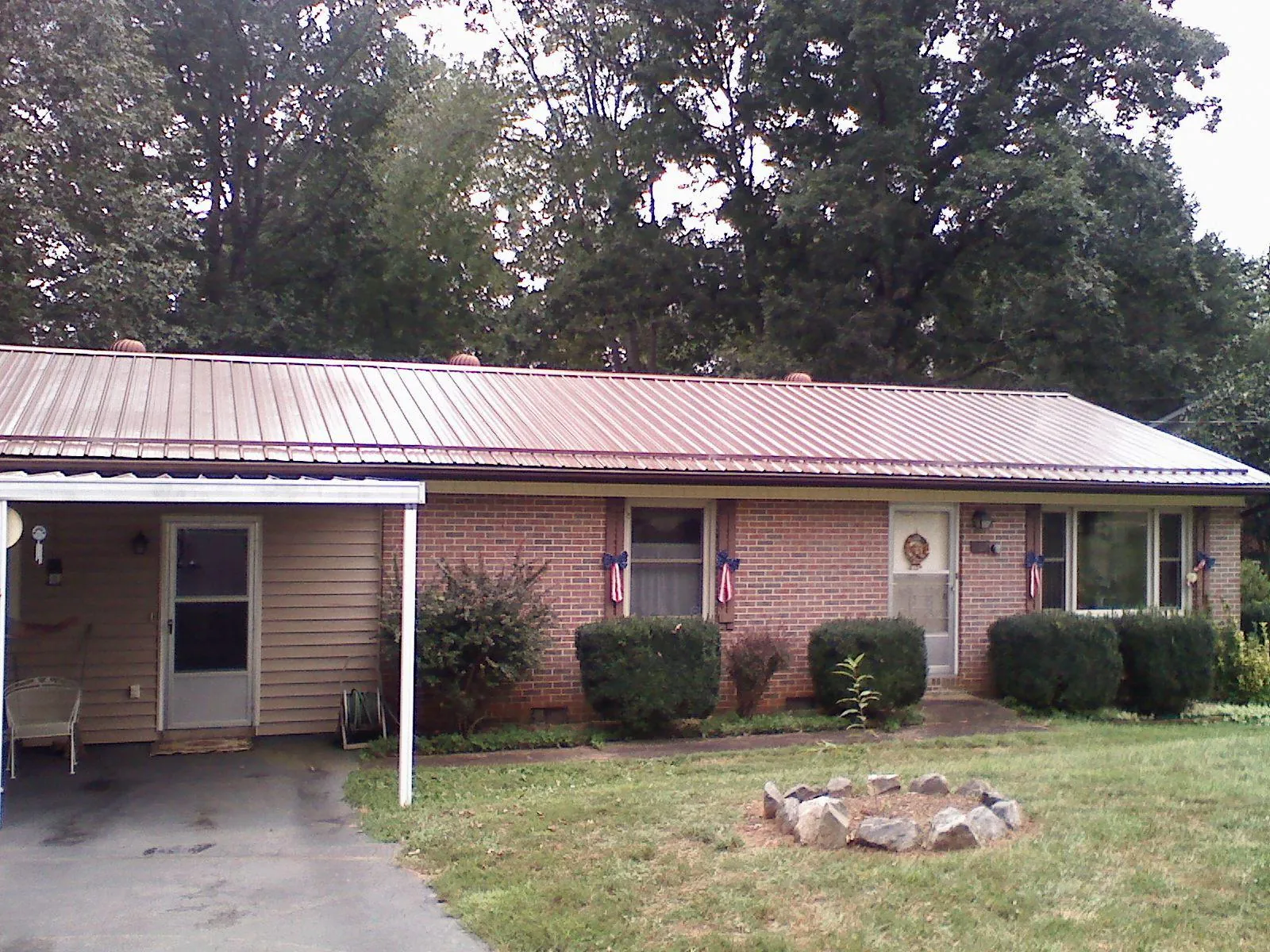 Bronze metal roof and carport on a brick ranch home — Roof Repair work by our crew in Dassel